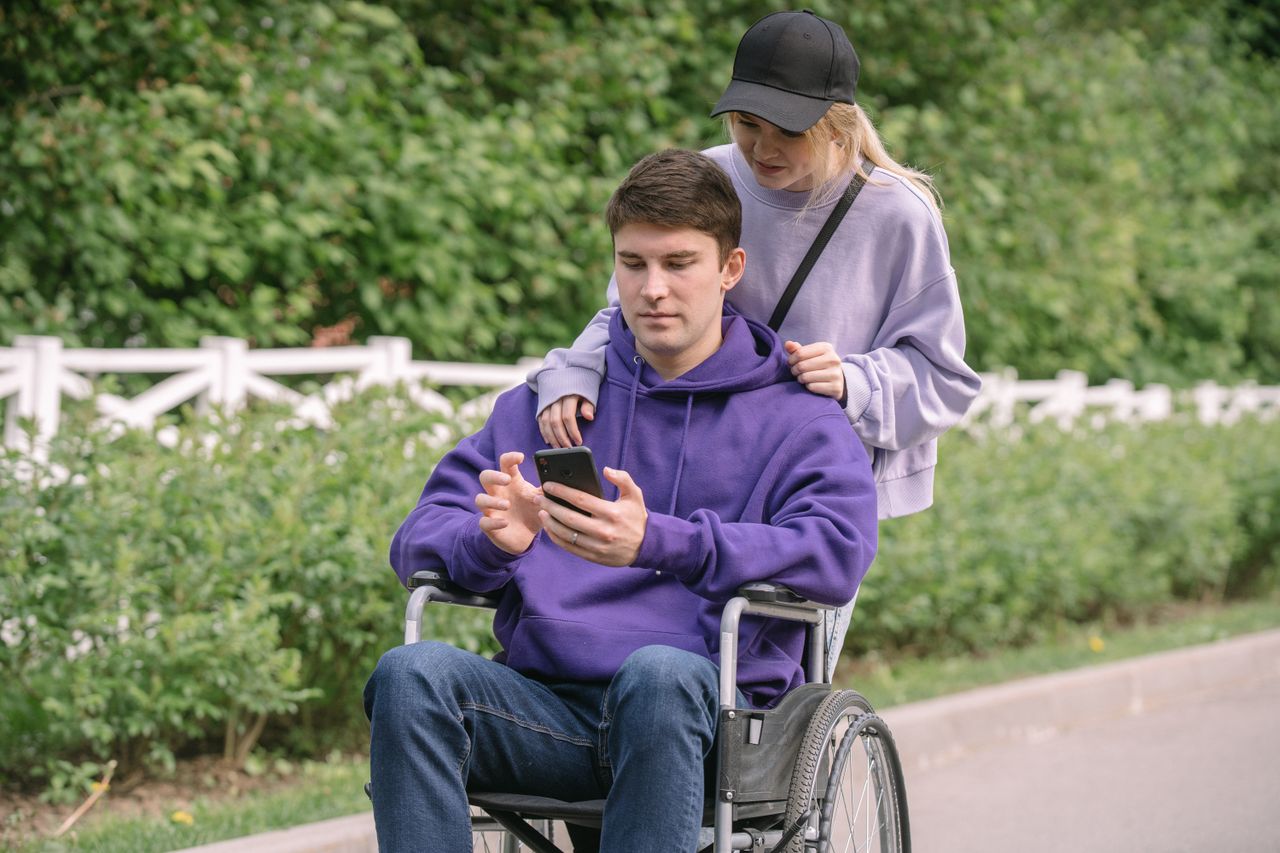 services-02 A young couple spends quality time outdoors with a smartphone, embracing love and accessibility.